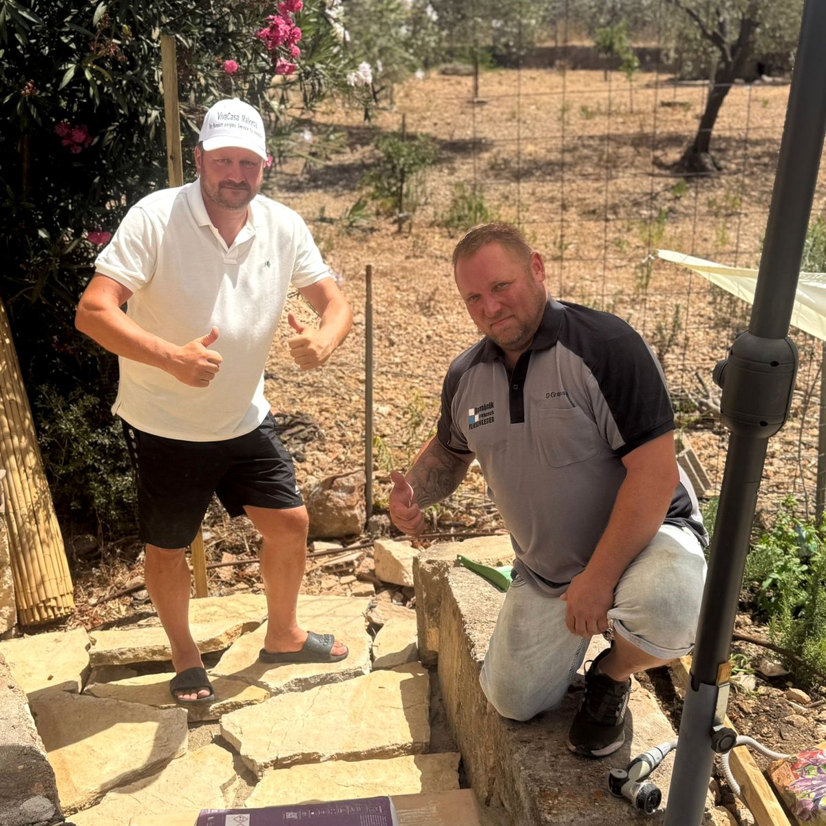 Matthias Radke von Vivacasa Mallorca und Fliesenlegermeister Dominik Grabosch beim Verlegen von Natursteinplatten